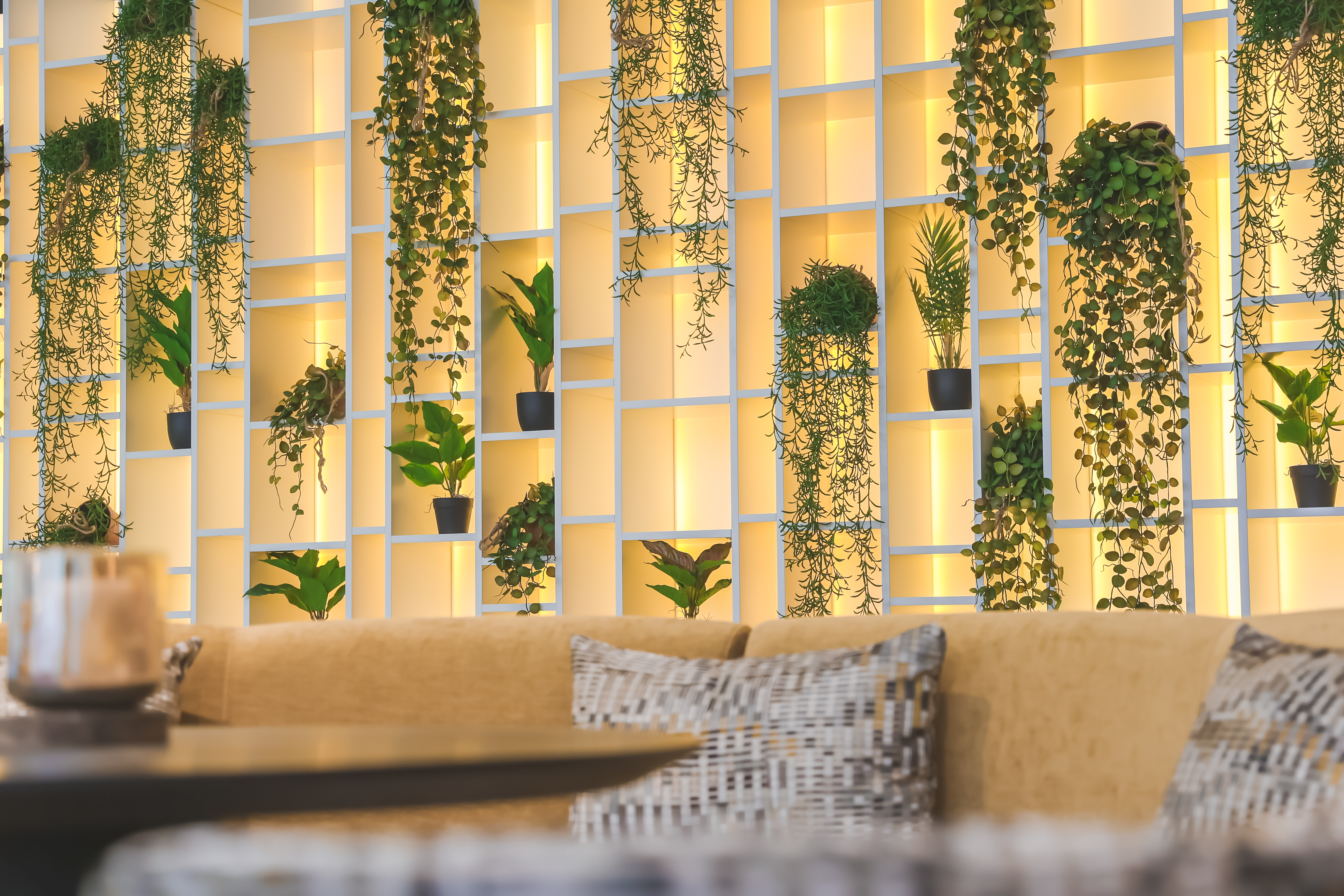 kastenmuur met planten en gele zetel